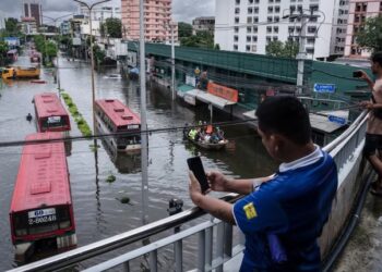 Ruas jalan di Bangkok tergenang banjir dengan kendaraan dan perahu evakuasi