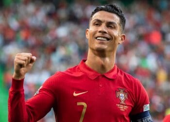 Cristiano Ronaldo mengenakan jersey Portugal dan mengepalkan tangan di lapangan