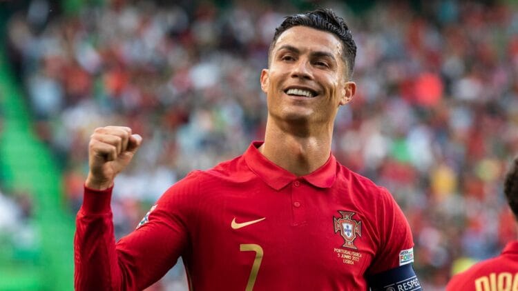 Cristiano Ronaldo mengenakan jersey Portugal dan mengepalkan tangan di lapangan
