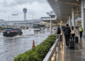 Ilustrasi penumpang menuju terminal bandara saat jalan tergenang banjir