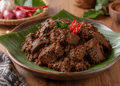 Ilustrasi rendang khas Padang dengan bumbu pekat dan potongan daging sapi