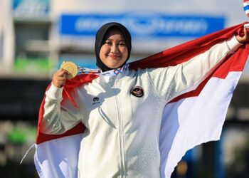 Nurisa Dian Ashrifah memegang medali emas dan bendera Indonesia