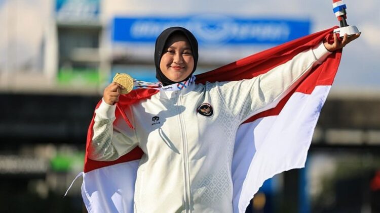 Nurisa Dian Ashrifah memegang medali emas dan bendera Indonesia
