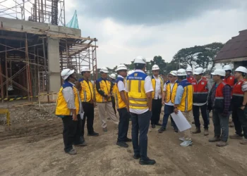 Sejumlah petugas dan pejabat memakai helm proyek meninjau pembangunan Sekolah Rakyat Tahap II di Nganjuk