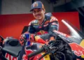 Maverick Vinales mengenakan baju balap dan topi KTM Red Bull di samping motor balap KTM