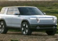 SUV listrik Rivian R2 berwarna biru muda dipotret dari sudut depan samping di area terbuka