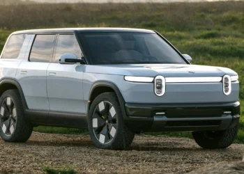 SUV listrik Rivian R2 berwarna biru muda dipotret dari sudut depan samping di area terbuka