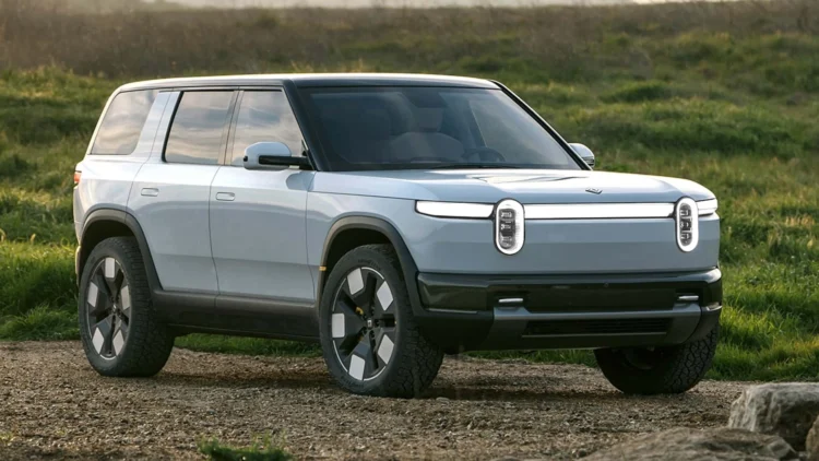 SUV listrik Rivian R2 berwarna biru muda dipotret dari sudut depan samping di area terbuka