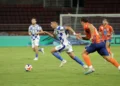 Luka Menalo mengenakan seragam Persib berwarna biru dan putih saat mengejar bola dalam pertandingan menghadapi Port FC