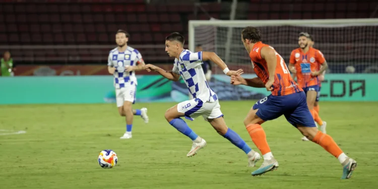 Luka Menalo mengenakan seragam Persib berwarna biru dan putih saat mengejar bola dalam pertandingan menghadapi Port FC