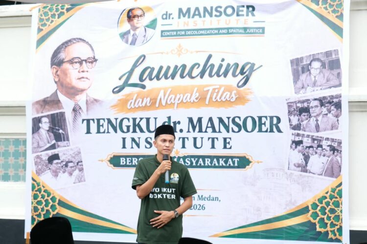 Seorang pria berbicara menggunakan mikrofon di depan spanduk peluncuran Tengku dr. Mansoer Institute