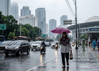 Seorang warga membawa payung saat melintas di Kawasan Senayan, Jakarta (Ilustrasi AI Bulatantimes