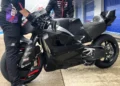 Motor prototipe Aprilia 850 cc dengan bodi hitam di dekat dua kru dalam area garasi