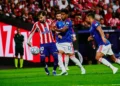Pemain Atletico Madrid berseragam merah-putih menguasai bola saat dihadang dua pemain Manchester United berbaju biru