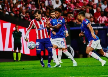 Pemain Atletico Madrid berseragam merah-putih menguasai bola saat dihadang dua pemain Manchester United berbaju biru