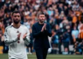 Michael Carrick bertepuk tangan di tepi lapangan dengan Bruno Fernandes berada di depannya