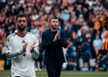 Michael Carrick bertepuk tangan di tepi lapangan dengan Bruno Fernandes berada di depannya