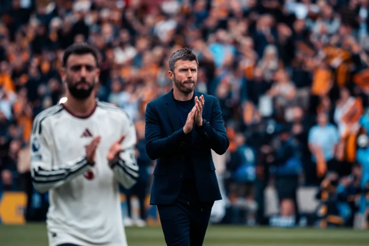 Michael Carrick bertepuk tangan di tepi lapangan dengan Bruno Fernandes berada di depannya