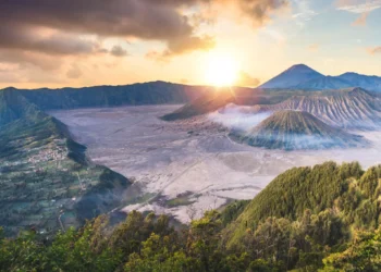 Panorama kaldera Gunung Bromo, Gunung Batok dan Gunung Semeru dengan cahaya matahari terbit di atas perbukitan