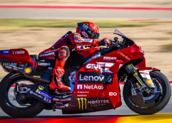 Marc Marquez mengendarai motor Ducati Lenovo berwarna merah saat melaju di lintasan balap.