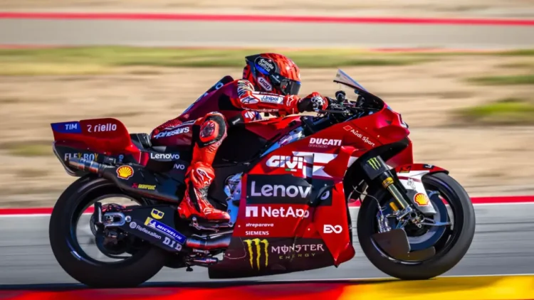 Marc Marquez mengendarai motor Ducati Lenovo berwarna merah saat melaju di lintasan balap.