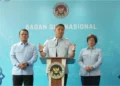 Kepala BGN Sudaryono berbicara di podium berlatar lambang Badan Gizi Nasional dengan dua pejabat di sisinya