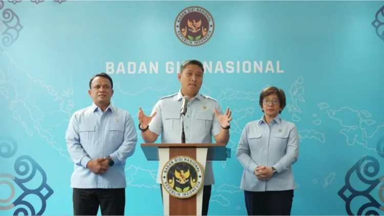 Kepala BGN Sudaryono berbicara di podium berlatar lambang Badan Gizi Nasional dengan dua pejabat di sisinya