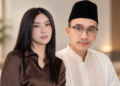 Seorang perempuan dan pria berpose bersama di dalam ruangan