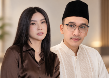 Seorang perempuan dan pria berpose bersama di dalam ruangan
