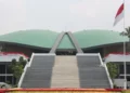 Tampak depan Gedung DPR RI dengan tangga utama, atap hijau, dan bendera Merah Putih