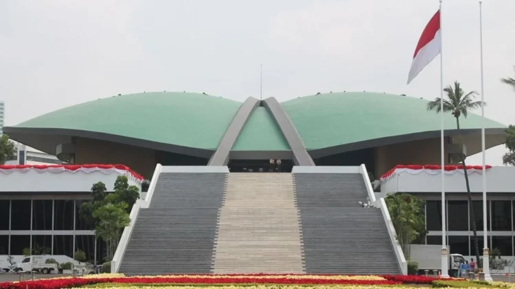 Tampak depan Gedung DPR RI dengan tangga utama, atap hijau, dan bendera Merah Putih