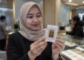 Ilustrasi seorang perempuan memegang emas batangan dalam kemasan di gerai emas