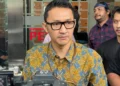 Juru Bicara KPK Budi Prasetyo mengenakan batik dan kacamata saat diwawancarai wartawan