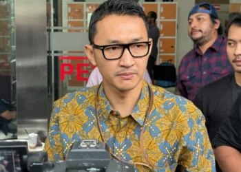 Juru Bicara KPK Budi Prasetyo mengenakan batik dan kacamata saat diwawancarai wartawan