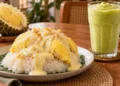 Ketan putih disajikan dengan daging durian kuning dan kuah kental di atas piring