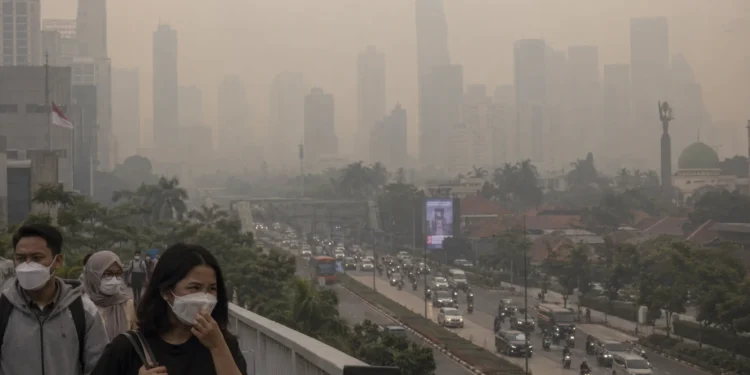 Ilustrasi warga mengenakan masker di jembatan penyeberangan dengan gedung perkotaan dan jalan raya yang tampak berkabut di belakangnya