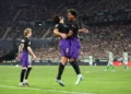 Lamine Yamal mengenakan seragam Barcelona hitam dan ungu merayakan gol bersama rekan setim di lapangan