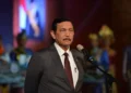 Luhut Binsar Pandjaitan mengenakan jas dan berbicara di depan mikrofon