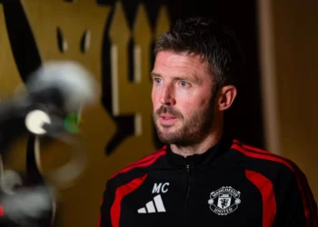 Michael Carrick mengenakan jaket latihan Manchester United saat berbicara di depan kamera