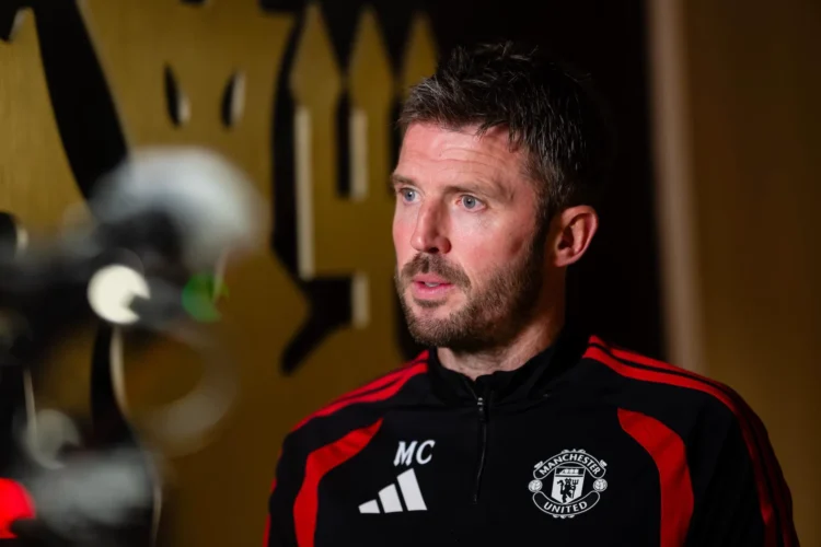 Michael Carrick mengenakan jaket latihan Manchester United saat berbicara di depan kamera