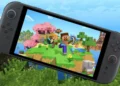 Konsol genggam Nintendo Switch 2 menampilkan permainan Minecraft dengan karakter Steve dan Alex di dunia blok berwarna cerah