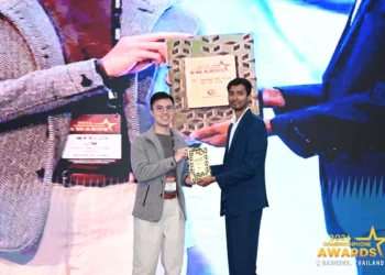 Dua orang berdiri di panggung sambil memegang plakat GamingonPhone Awards 2026, dengan layar acara penghargaan di belakangnya