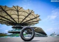 Ban balap Michelin berdiri di permukaan Sirkuit Sepang dengan tribun utama di latar belakang