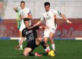 Pemain Como berseragam hitam berusaha merebut bola dari pemain Venezia berseragam putih dalam pertandingan sepak bola