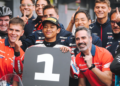 Veda Ega Pratama mengenakan seragam Honda Team Asia dan berpose bersama anggota tim di belakang papan nomor satu setelah meraih pole position Moto3.