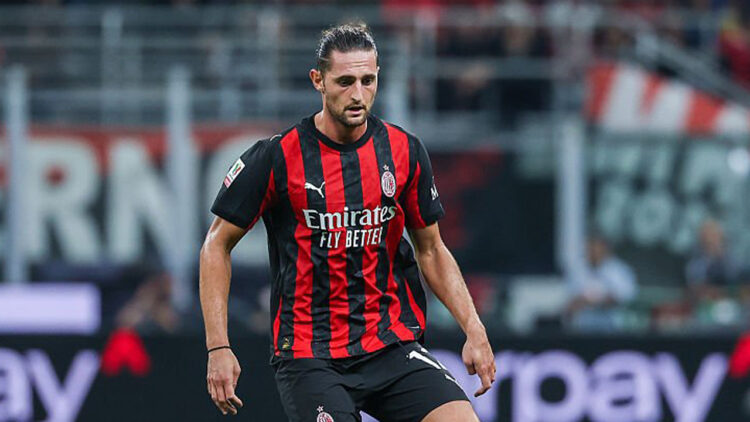 Adrien Rabiot mengenakan seragam merah hitam AC Milan di lapangan