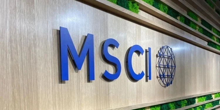 Logo bertuliskan MSCI berwarna biru pada dinding dengan panel tanaman hijau