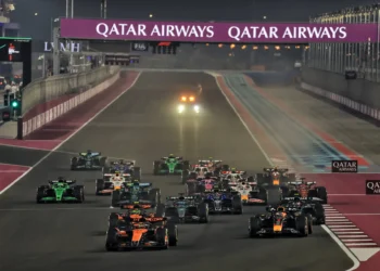 Sejumlah mobil Formula 1 berlomba di lintasan malam Lusail dengan papan sponsor Qatar Airways di atas trek.