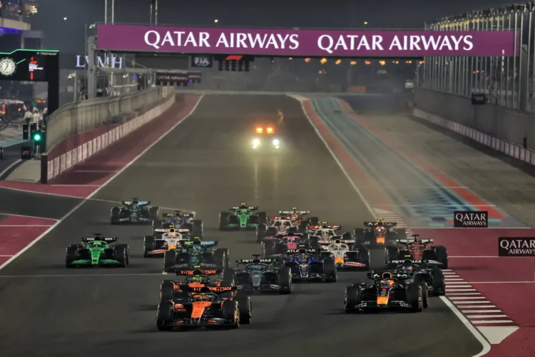 Sejumlah mobil Formula 1 berlomba di lintasan malam Lusail dengan papan sponsor Qatar Airways di atas trek.