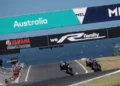 Dua motor balap melaju di lintasan dengan papan bertuliskan Australia di atasnya.